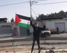 Un jeune palestinien lève le drapeau de la Palestine sur les ruines de son magasin à Ramallah